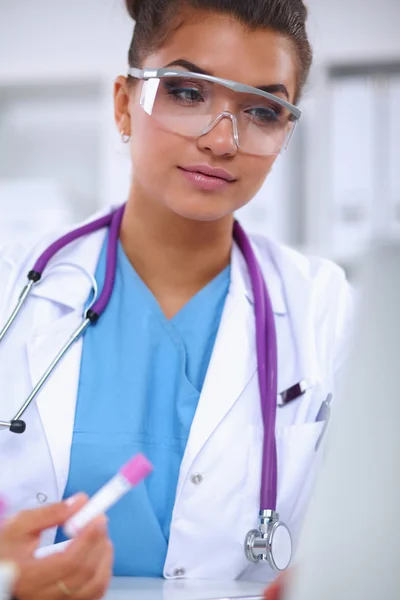 Kvinnlig forskare är omgiven av medicinska flaskor och kolvar, isolerade på vit bakgrund — Stockfoto