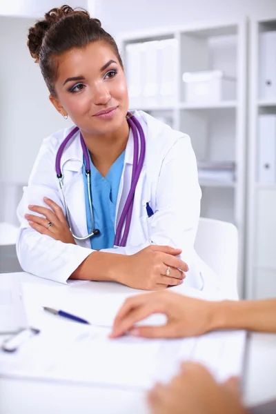 Médico e paciente sentado na mesa no escritório — Fotografia de Stock