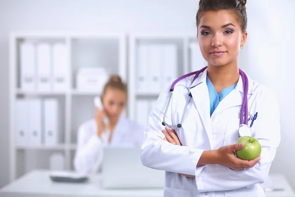 Portrait of young woman doctor with white coat standing in hospital — Stock Photo, Image