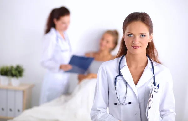 Médico sonriente con una carpeta en uniforme de pie en el hospital — Foto de Stock