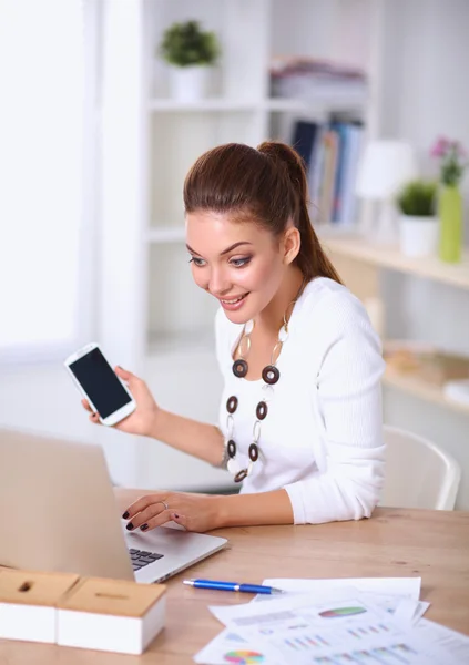 Joven mujer de negocios sentada en el escritorio y hablando por teléfono — Foto de Stock