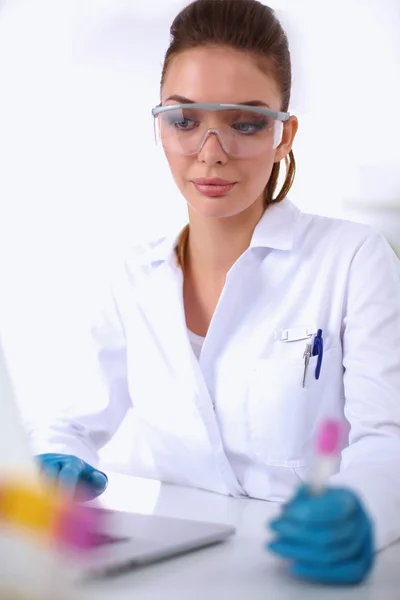 Woman researcher is surrounded by medical vials and flasks, isolated on white background — Stock Photo, Image