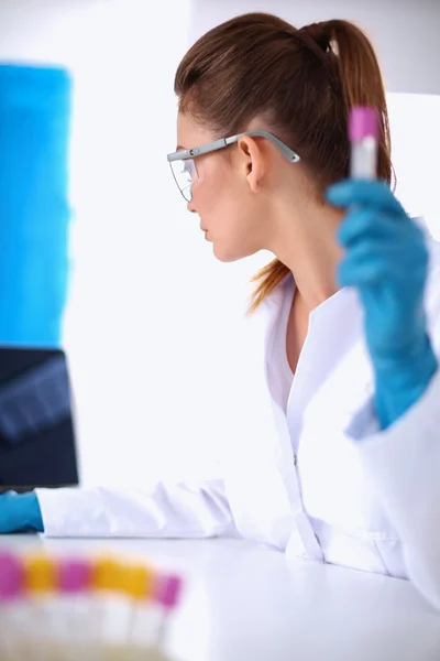 Woman researcher is surrounded by medical vials and flasks, isolated on white background — Stock Photo, Image