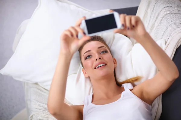 Glückliche Brünette macht ein Foto von sich mit ihrem Handy im Schlafzimmer — Stockfoto