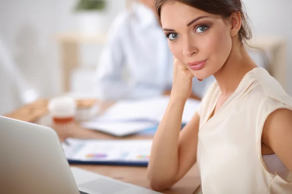 Aantrekkelijke zakenvrouw zit op het bureau in het kantoor — Stockfoto