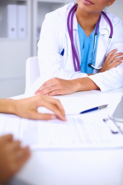 Doktor ve hasta ofiste masada oturuyorlar.
