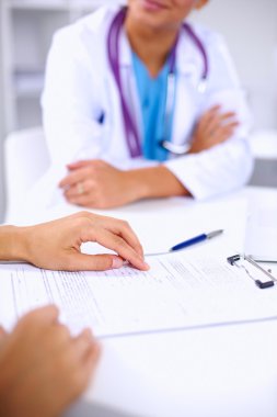 Doktor ve hasta ofiste masada oturuyorlar.