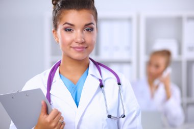 Gülümseyen kadın doktor, üniformalı bir klasörle Hostp 'ta bekliyor.