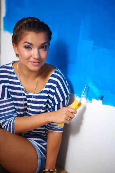 Szczęśliwa piękna młoda kobieta maluje ściany, — Zdjęcie stockowe