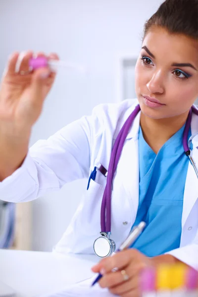 Vrouwelijke onderzoeker is omgeven door medische flacons en flacons, iso — Stockfoto