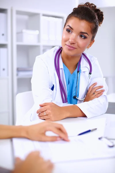 Médico e paciente sentado na mesa no escritório — Fotografia de Stock