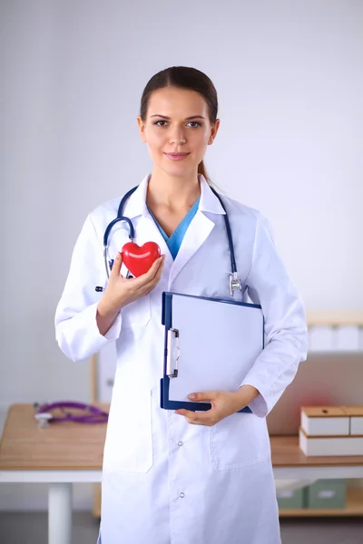 Klasör ve izole üzerinde kırmızı bir kalp tutan genç bir kadın doktor — Stok fotoğraf