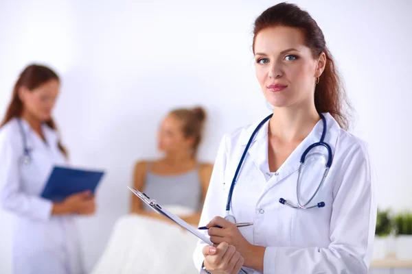 Usmívající se doktorka se složkou v uniformě stojící na hosp — Stock fotografie