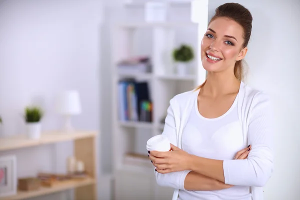 Attraktive junge Geschäftsfrau steht an Wand im Büro — Stockfoto