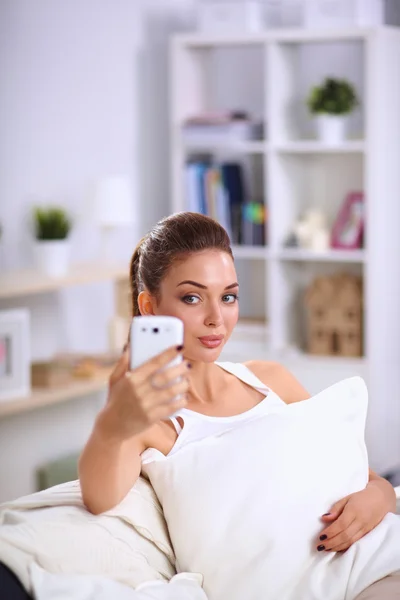 Happy brunette taking a photo of herself with her mobile phone — Stock Photo, Image