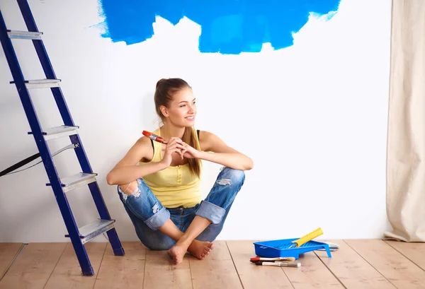 Retrato de pintora sentada en el suelo cerca de la pared después de pai — Foto de Stock