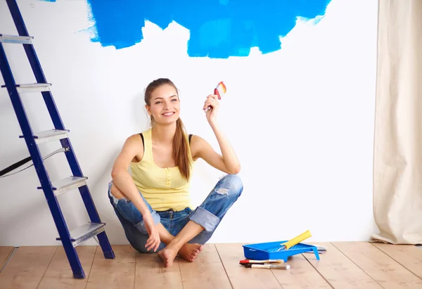 Retrato de pintora sentada en el suelo cerca de la pared después de pai — Foto de Stock