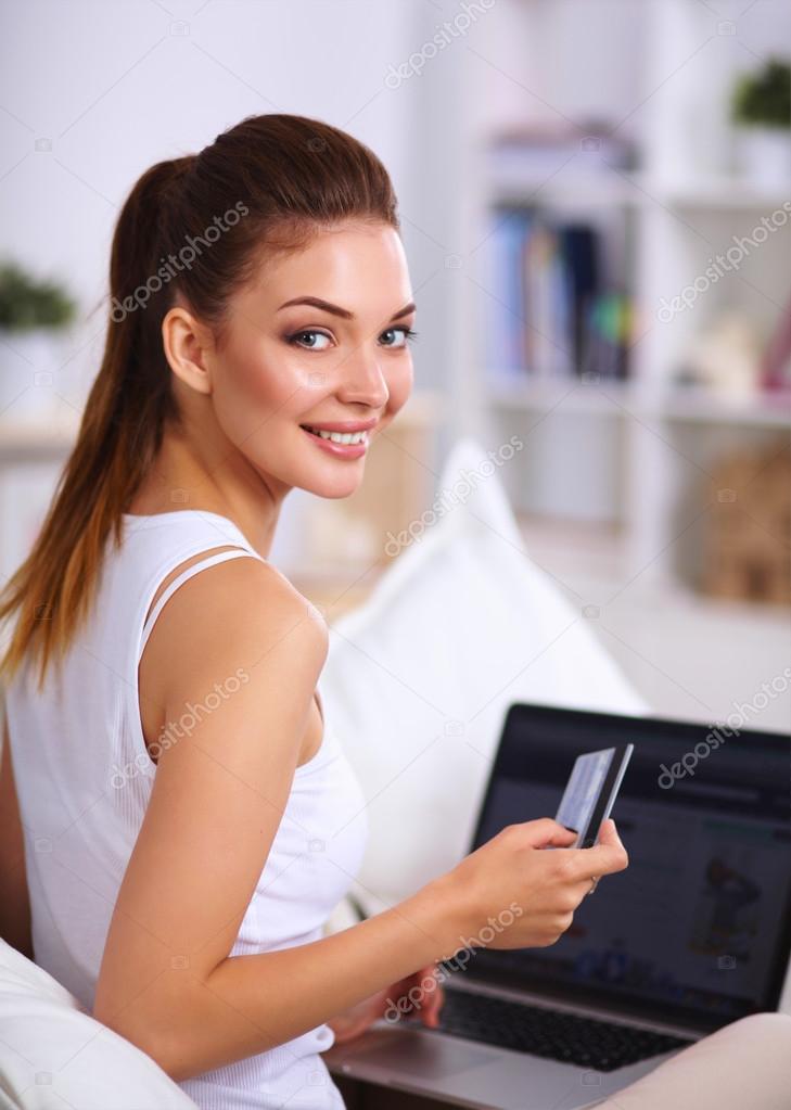 Woman shopping online with credit card and computer.