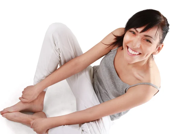 Mooie jonge vrouw zittend op de vloer, geïsoleerde witte achtergrond — Stockfoto