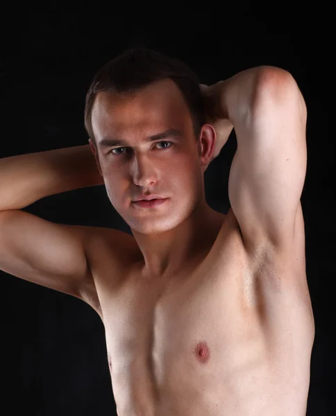 Портрет обнаженного мускулистого человека, изолированного на черном — стоковое фото