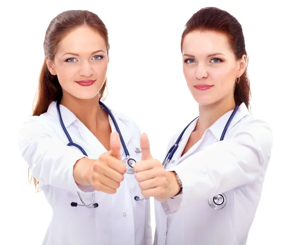 Zwei junge Ärztinnen zeigen Okay, stehen im Krankenhaus — Stockfoto