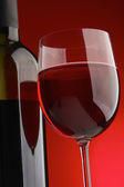 láhev s červeným vínem a sklo