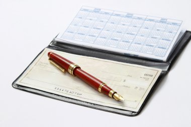açık bir çek defteri ve üzerinde beyaz izole bir ballpen