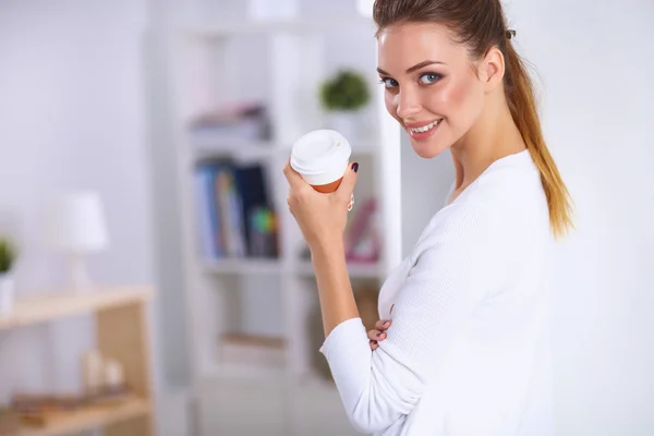 Attraktive junge Geschäftsfrau steht an Wand im Büro — Stockfoto