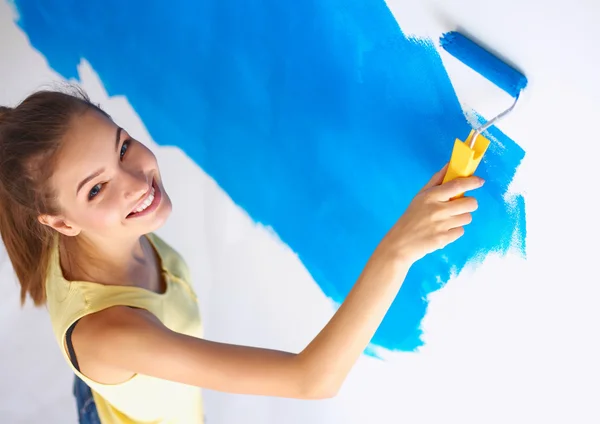 Joyeux belle jeune femme faisant de la peinture murale, debout sur l'échelle — Photo