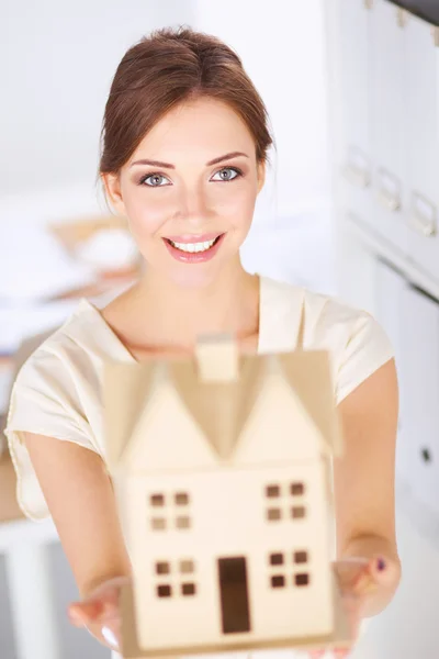 Retrato de una arquitecta sosteniendo una casita, de pie en la oficina, aislada —  Fotos de Stock