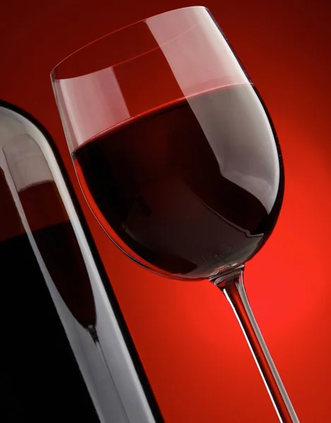 Elegante bicchiere di vino e una bottiglia di vino su sfondo nero . — Foto Stock