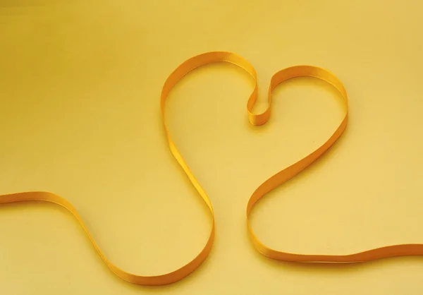 Uma fita amarela na forma de um coração — Fotografia de Stock