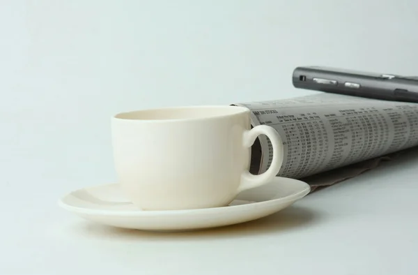 Una tazza di caffè, un cellulare e un giornale — Foto Stock