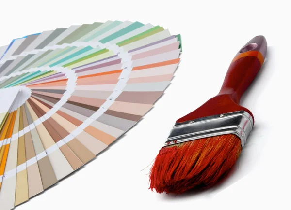 Primer plano de una paleta de colores y un pincel, aislado en la espalda blanca — Foto de Stock