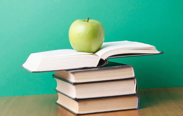 An apple on a pile of books — Stock Photo, Image