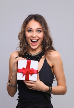 genç kadın mutlu gülümseme hediye kutusu gri arka plan üzerinde izole elinde tut