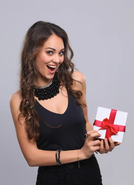 Mujer joven sonrisa feliz celebrar caja de regalo en las manos, aislado sobre fondo gris —  Fotos de Stock