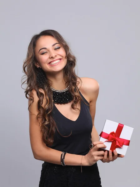 Young woman happy smile hold gift box in hands, isolated over grey background — Stock Photo, Image