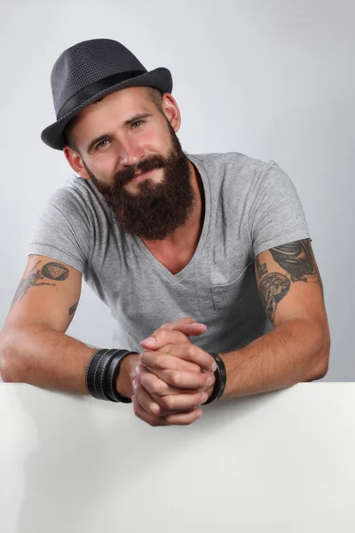 Retrato de jovem de chapéu em pé perto de branco, isolado sobre fundo branco — Fotografia de Stock