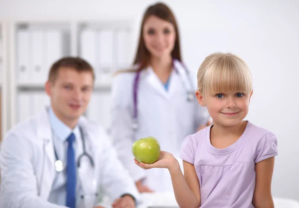 Concepto de niño y medicina - doctora dando una manzana a una niña sonriente —  Fotos de Stock