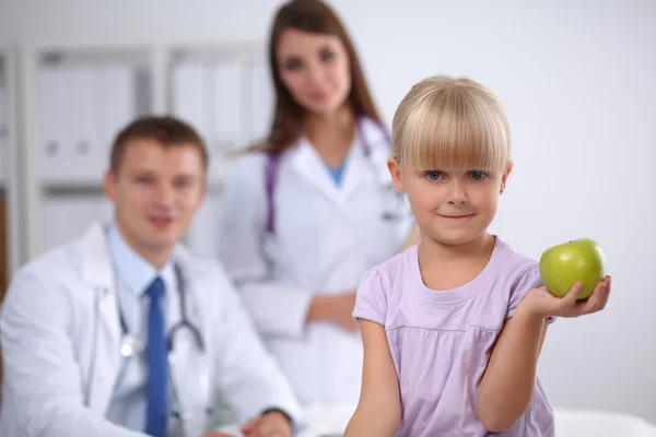 子供と医療の概念-女性医師が笑顔の女の子にリンゴを与える — ストック写真