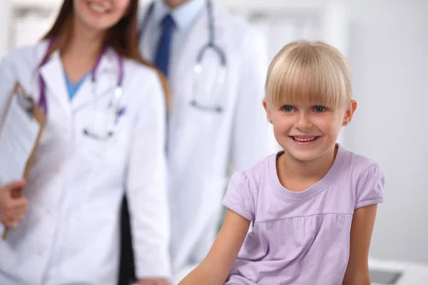 Hastanede küçük bir kız ve genç bir doktor muayene oluyor. — Stok fotoğraf