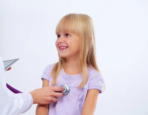 Médico femenino examinando a un niño con estetoscopio en cirugía — Foto de Stock