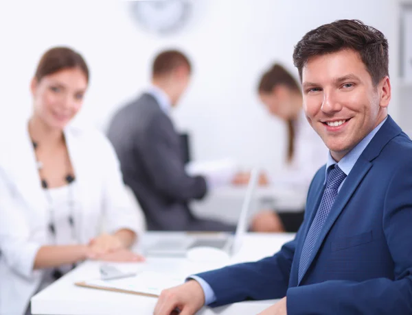 Beautiful young business people with colleagues discussing in the background — Stock Photo, Image