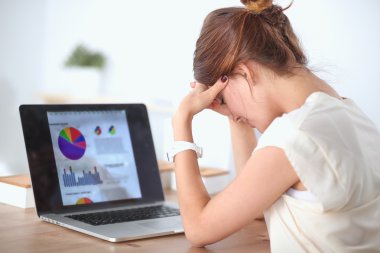 yorgun bir genç iş kadını ofiste dizüstü bilgisayar ile portresi