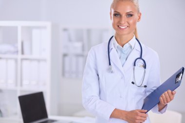 Hastanede üniformalı, gülümseyen bir kadın doktor.