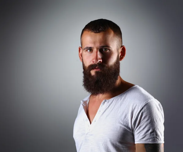 Retrato de hombre barbudo guapo de pie, aislado sobre fondo gris — Foto de Stock