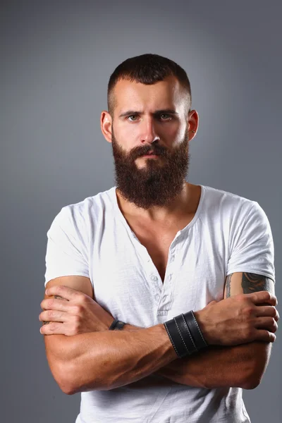 Gri arka plan üzerinde izole çapraz kollu yakışıklı sakallı adam portresi — Stok fotoğraf