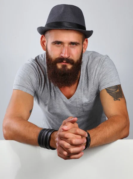 Retrato de un joven con sombrero de pie cerca del blanco, aislado sobre fondo blanco —  Fotos de Stock