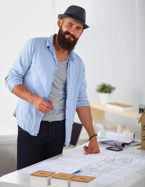 Portrait of male designer in hat with blueprints at desk — Stock Photo, Image